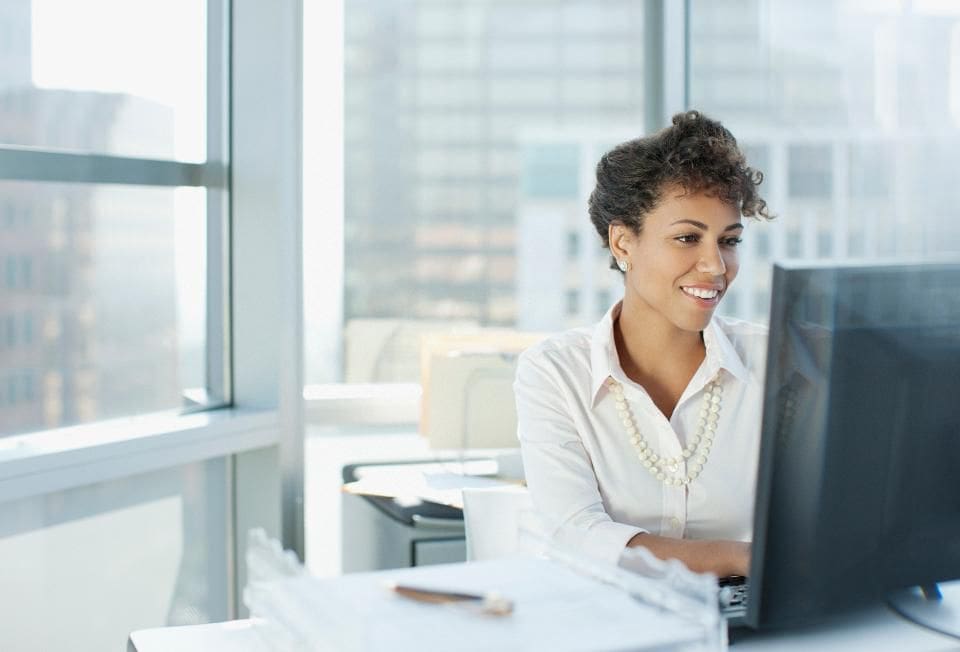Woman sitting at computer in corner office